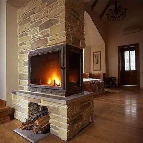 Камін посередині кімнати в деревяному будинку: фото