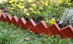 Декоративні огорожі для клумби своїми руками: бордюри та паркани з дерева, пластику, каменю і пляшок, фото і відео